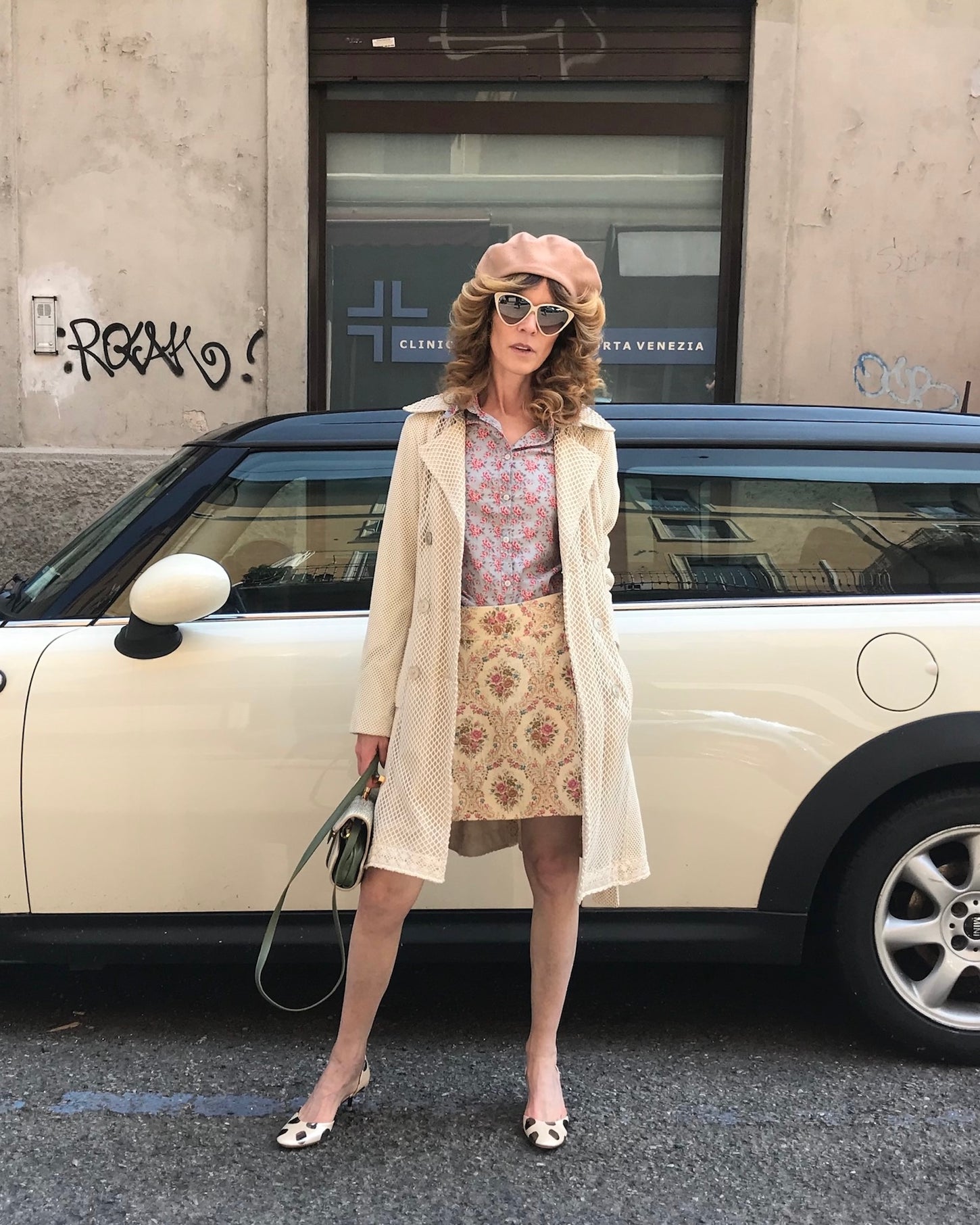 Immagine copertina per la sezione abiti Vintage con la foto di una donna davanti ad un auto che indossa abiti in stile anni 70