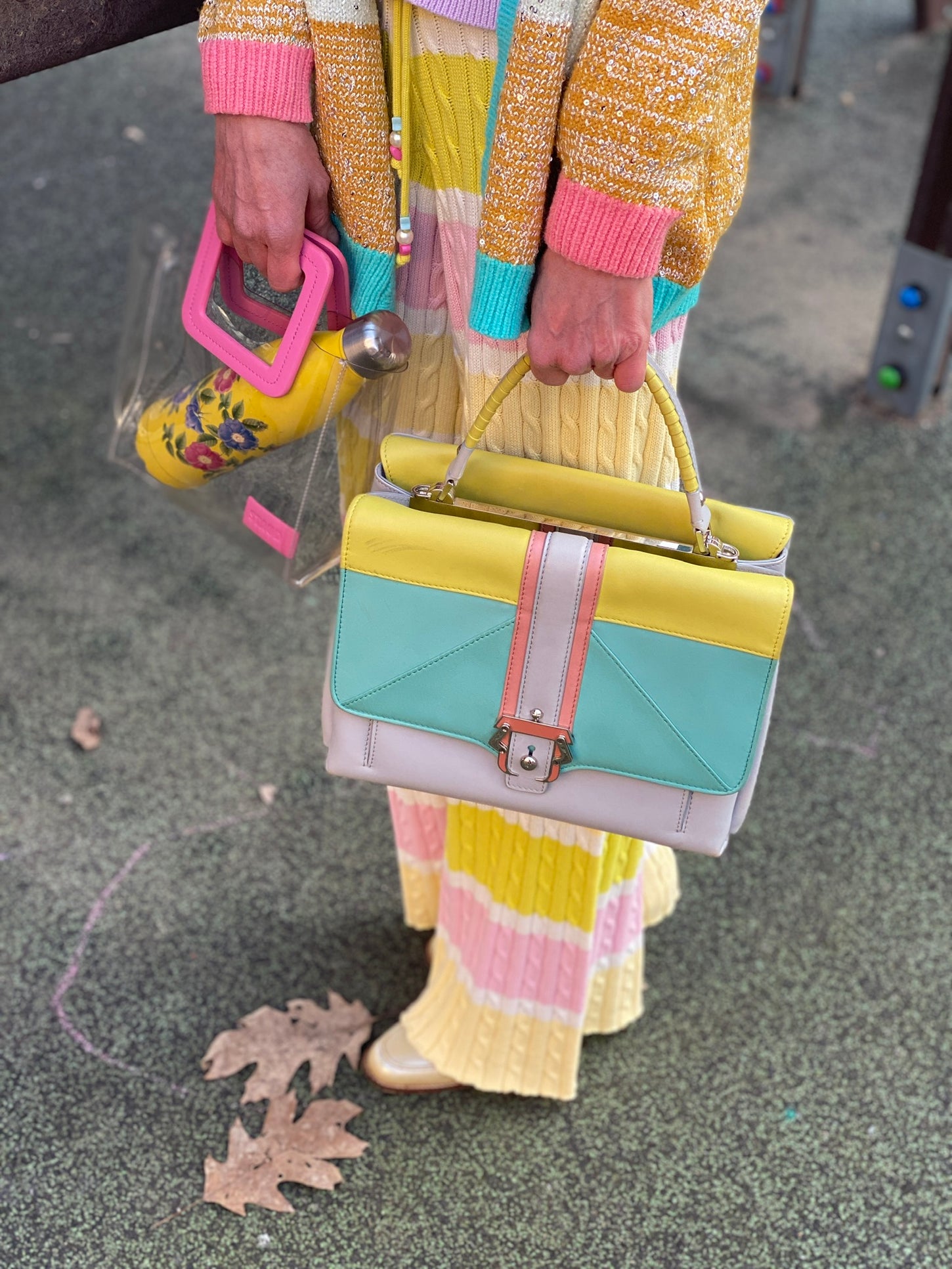 Immagine copertina per la collezione borse e pelletteria con il close up di una donna che tiene in mano due borse colorate